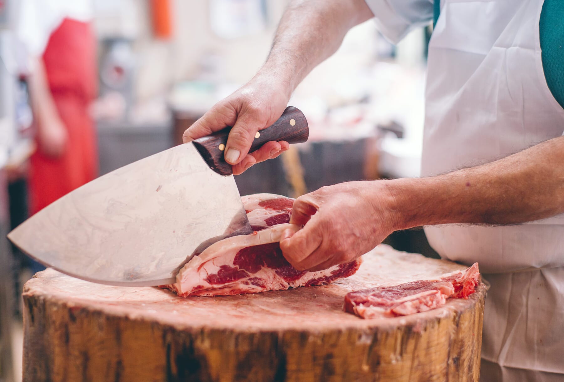 Grand Peaks Prime Meats Butcher slicing meat on wood surface